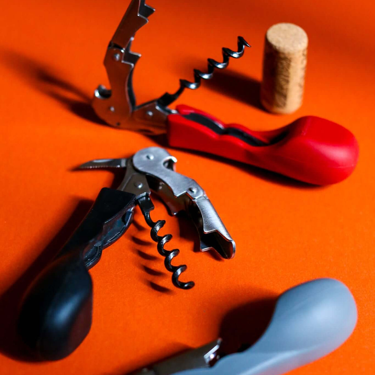 Silicone handled corkscrews by CapaBunga in red, black, and gray with wine cork.