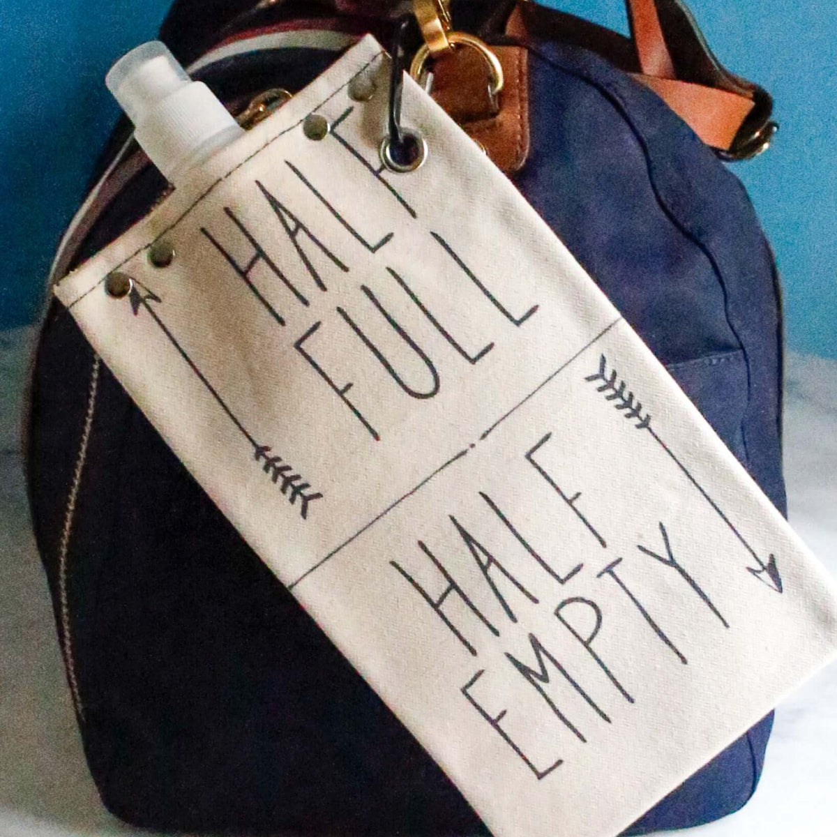 Canvas canteen with 'Half Full' and 'Half Empty' labels on a stylish bag, perfect for carrying beverages.