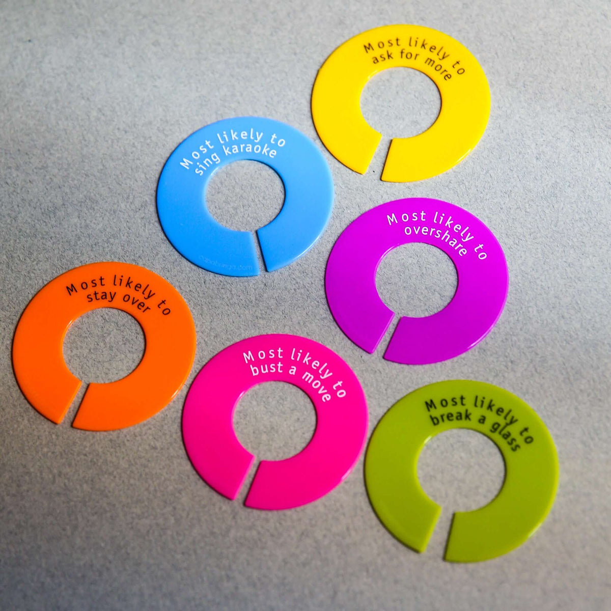Colorful silicone wine glass identifiers with humorous labels for parties, enhancing fun and preventing glass mix-ups.