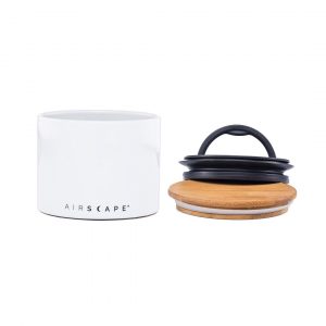 Photo of a white airscape ceramic coffee storage container with a wooden and black plastic lid.