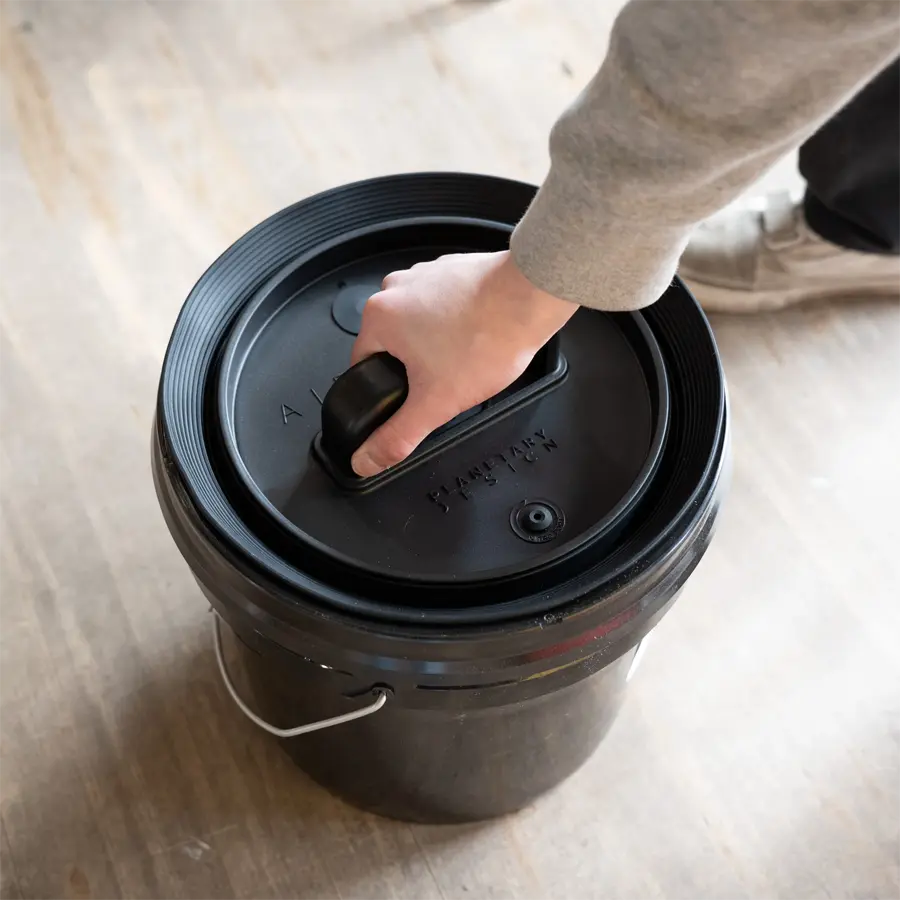 person putting an airscape bucket lid insert in a bucket