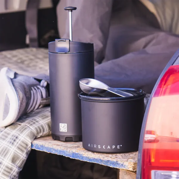 coffee french press bundle sitting at the back of a car camping set up