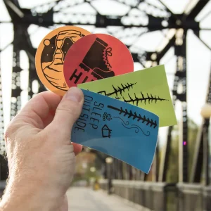 person holding outdoor coffee stickers