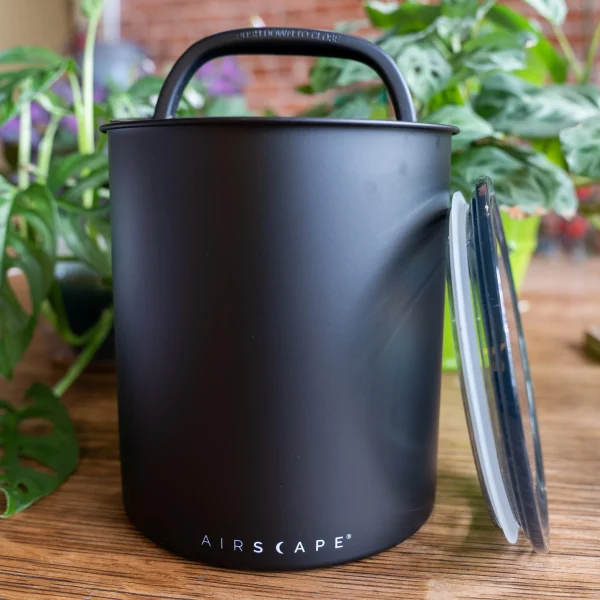 Coffee container in front of plants