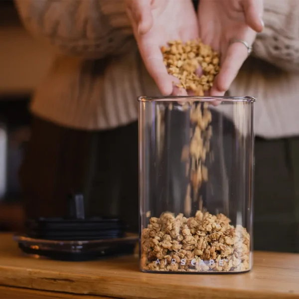 Person pouring granola in food storage container