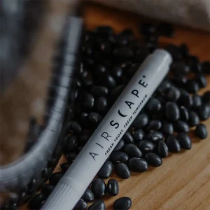 writer pen next to glass coffee jar in coffee beans