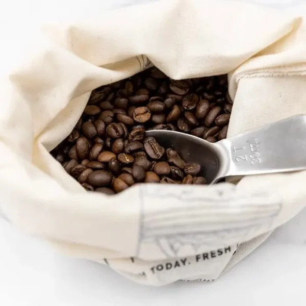 cotton bag filled with coffee and a coffee spoon inside