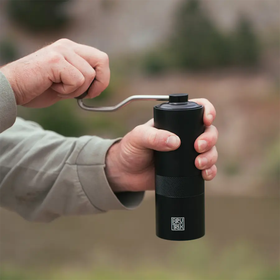 Person hand grinding coffee in the outdoors