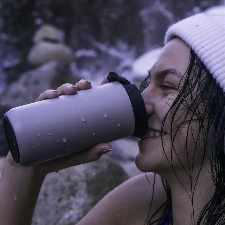 woman drinking coffee from a mug in a hot spring