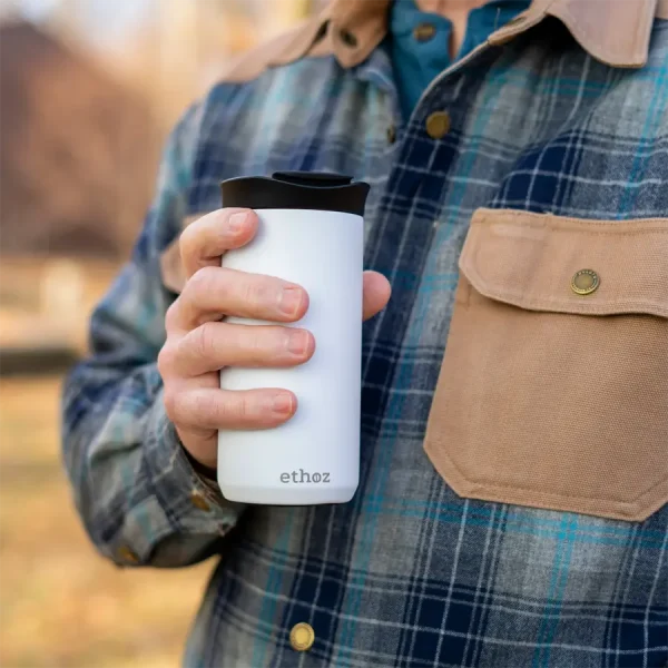 person in plaid holding a coffee mug