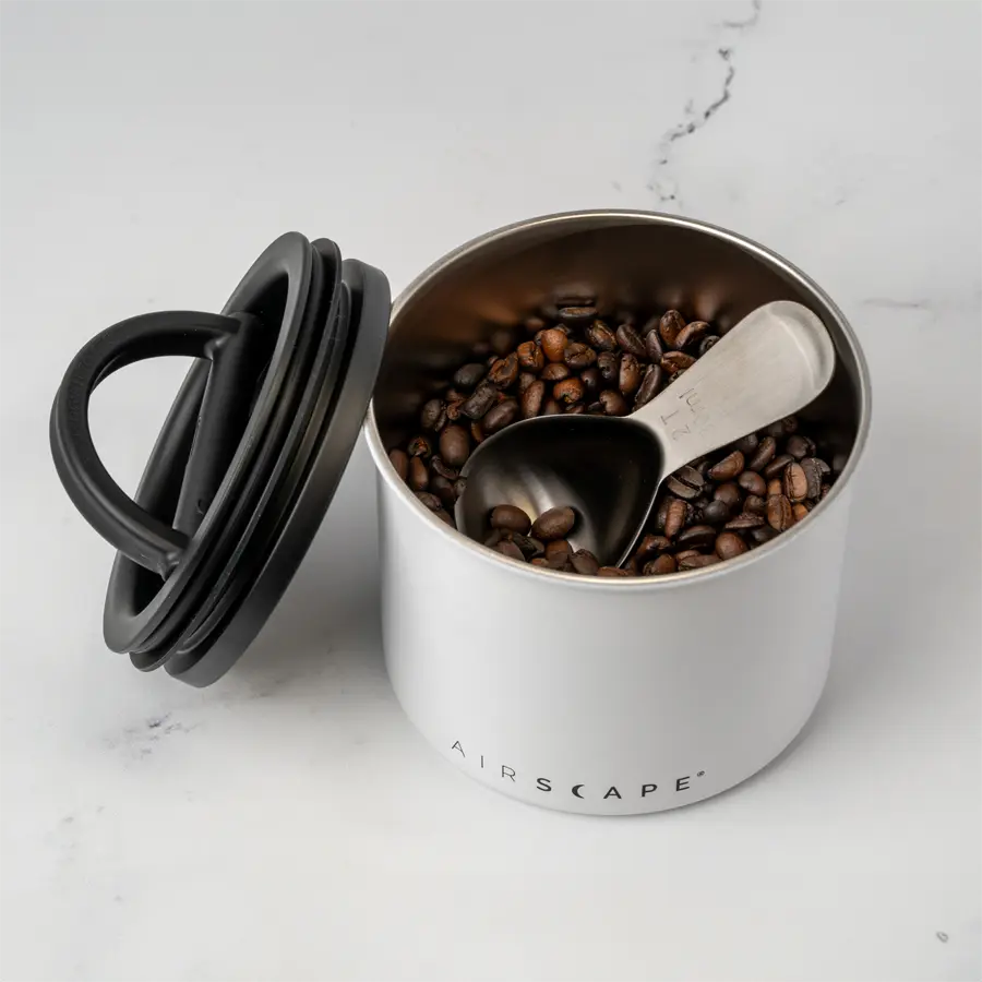 small white coffee storage container with coffee inside on kitchen counter